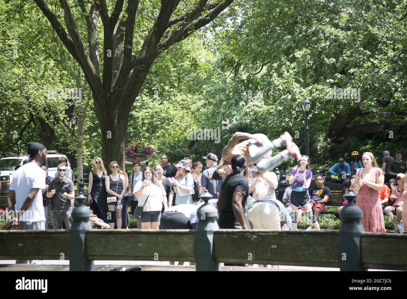 Les artistes acrobatiques font participer les touristes et les habitants de la région à leurs talents et à leur style humoristique. Central Park, New York. Banque D'Images