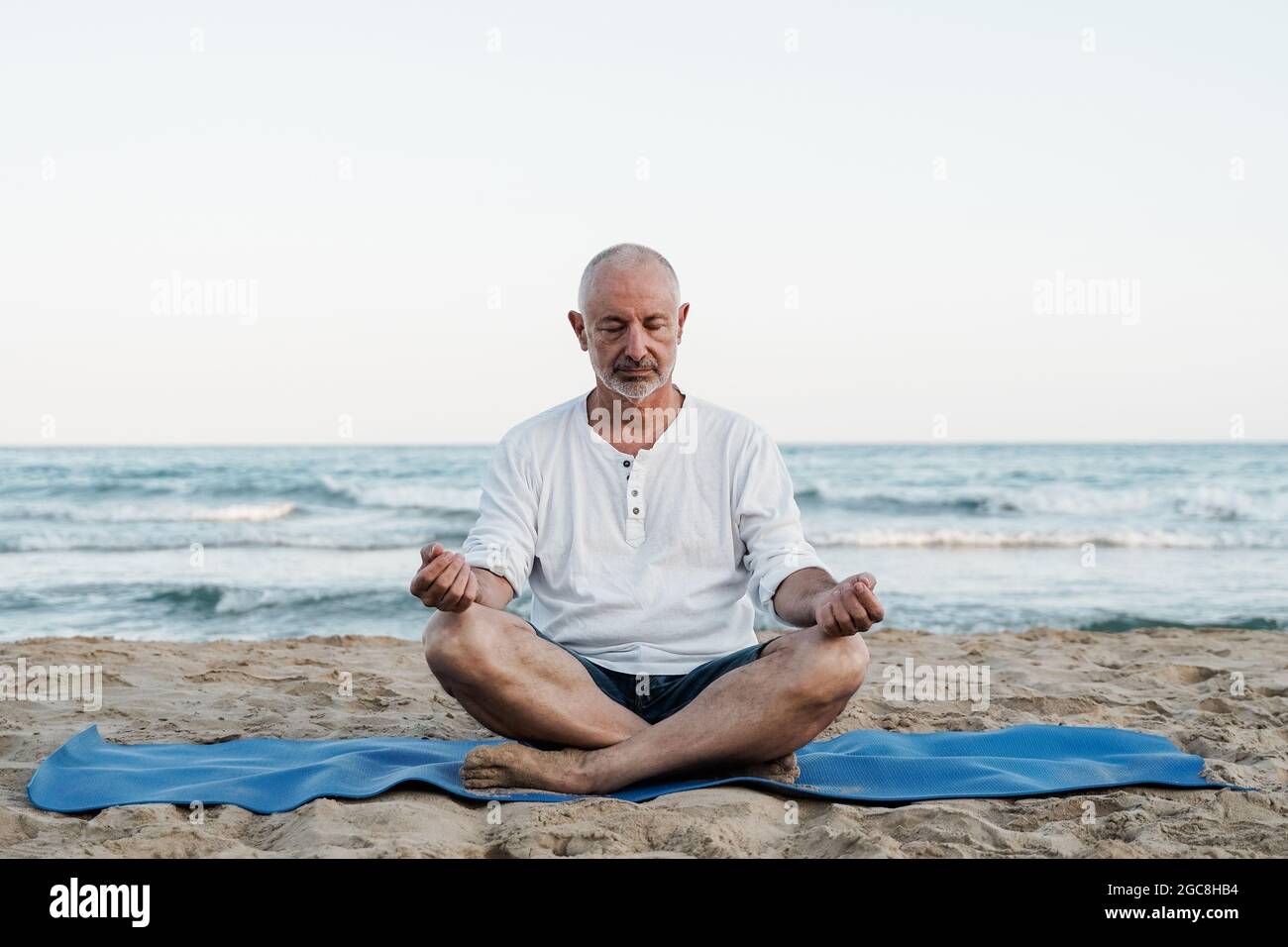 Homme senior faisant la meditation de yoga en plein air a la plage personnes agees et mode de vie sain Focus sur le visage Photo Stock Alamy