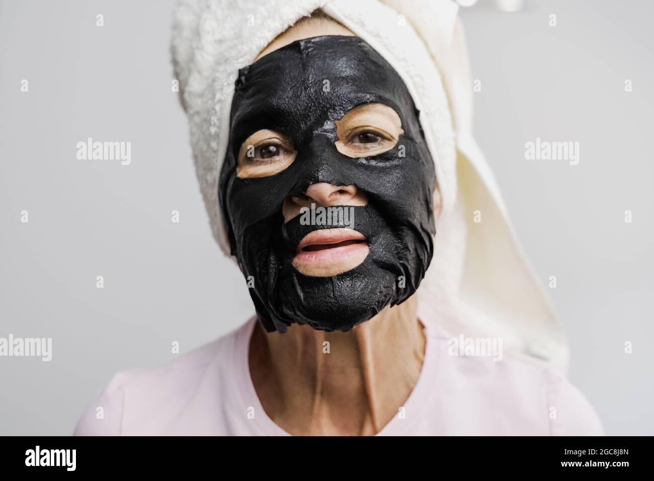 Femme âgée utilisant le masque facial de charbon de bois - Beauté soins de peau concept de mode de vie sain - Focus sur la bouche Banque D'Images