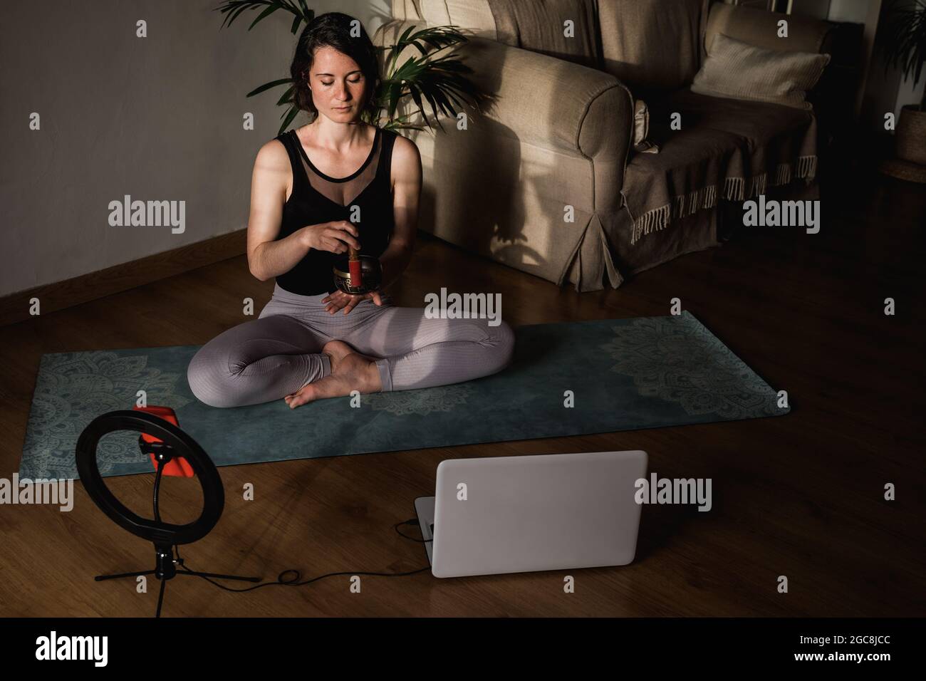Entraîneur de yoga enseignant de diffusion en ligne de cours de méditation pour le séminaire en ligne leçon avec smartphone à la maison - Focus sur le visage de fille Banque D'Images