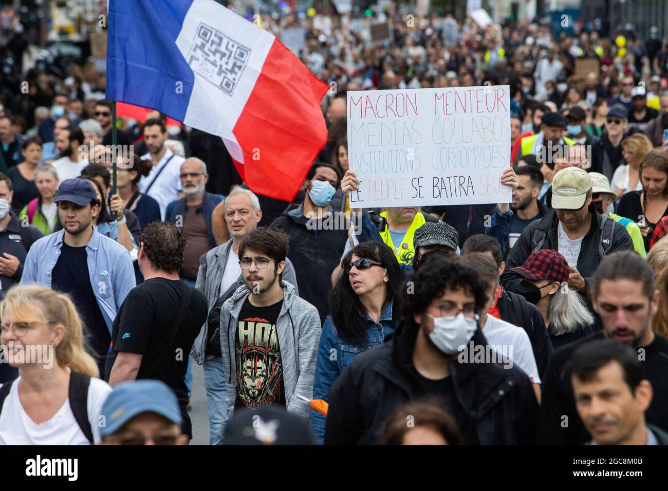 Le protestant tient un signe Macron Liar, Medias Collapos, les institutions corrompues, le peuple se battra seul lors d'une journée nationale de protestation contre la vaccination obligatoire Covid-19 pour certains travailleurs et l'utilisation obligatoire de la carte de santé exigée par le gouvernement français à Paris le 7 août 2021. Samedi, les manifestants sont descendus dans les rues à travers la France pour le quatrième week-end de suite pour se rassembler contre un nouveau passe de santé nécessaire pour entrer dans un café ou voyager dans un train interurbain, deux jours avant l'entrée en vigueur des nouvelles règles. Un passe de santé valide est généré par deux jabs d'un vaccin reconnu Banque D'Images