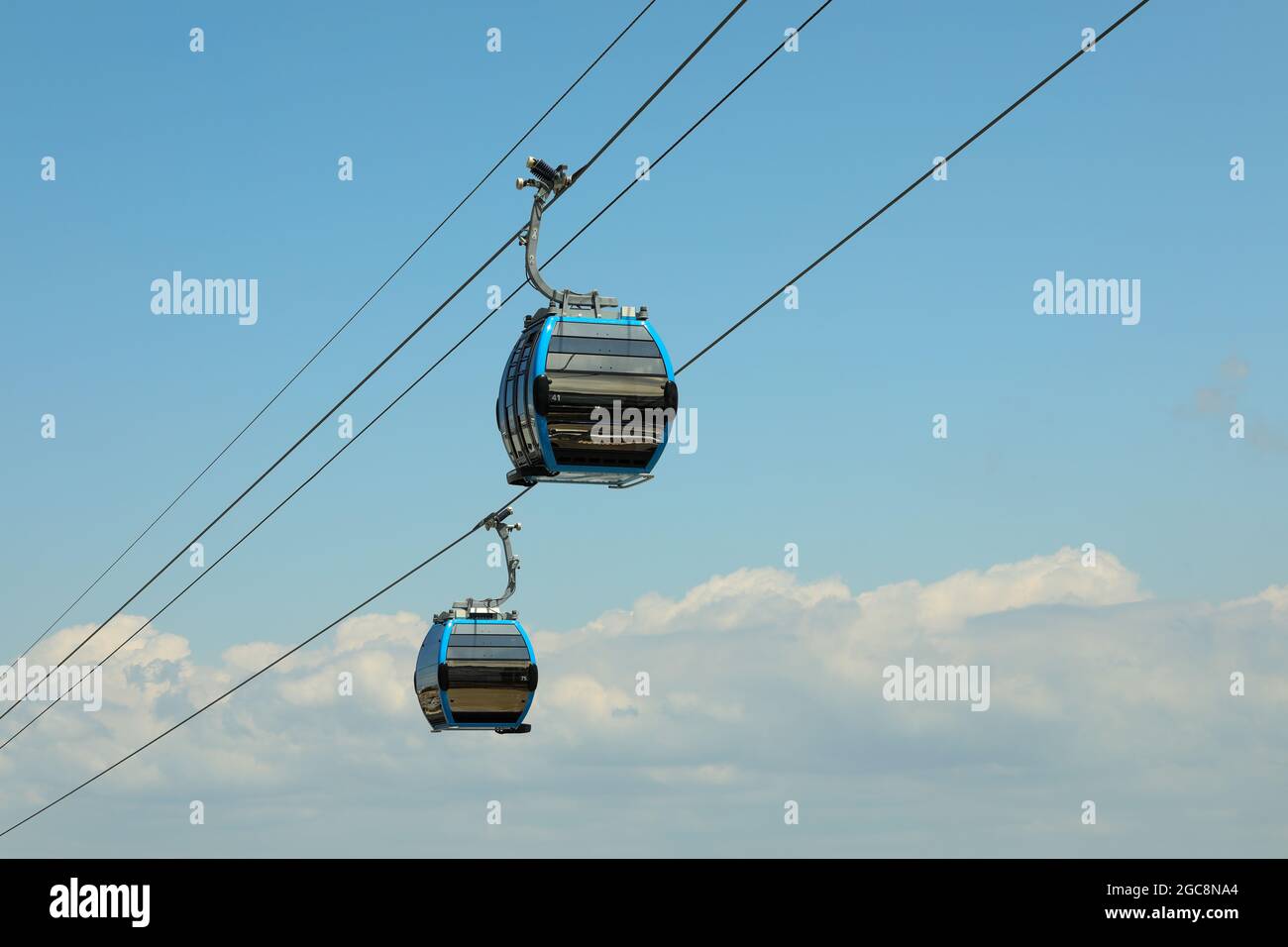 Cabines de téléphérique contre ciel et nuages étonnants. Téléphérique, transport vert. Banque D'Images