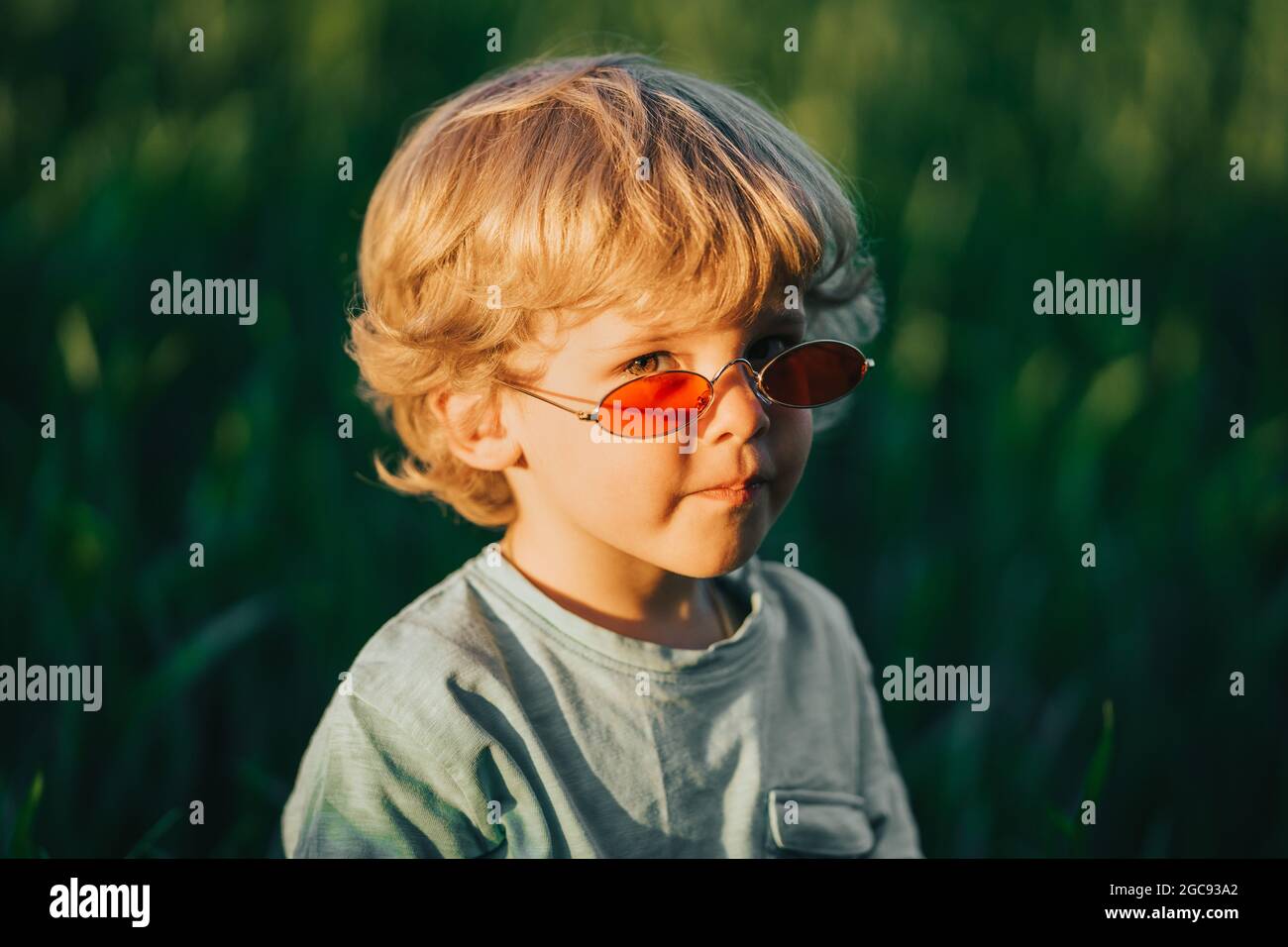 Drole De Cheveux Boucles Bebe Garcon Dans Des Lunettes De Soleil Rouges Debout Dans Le Champ De Ble Vert Frais Un Enfant Adorable Explore Les Plantes La Nature Au Printemps Enfance Photo
