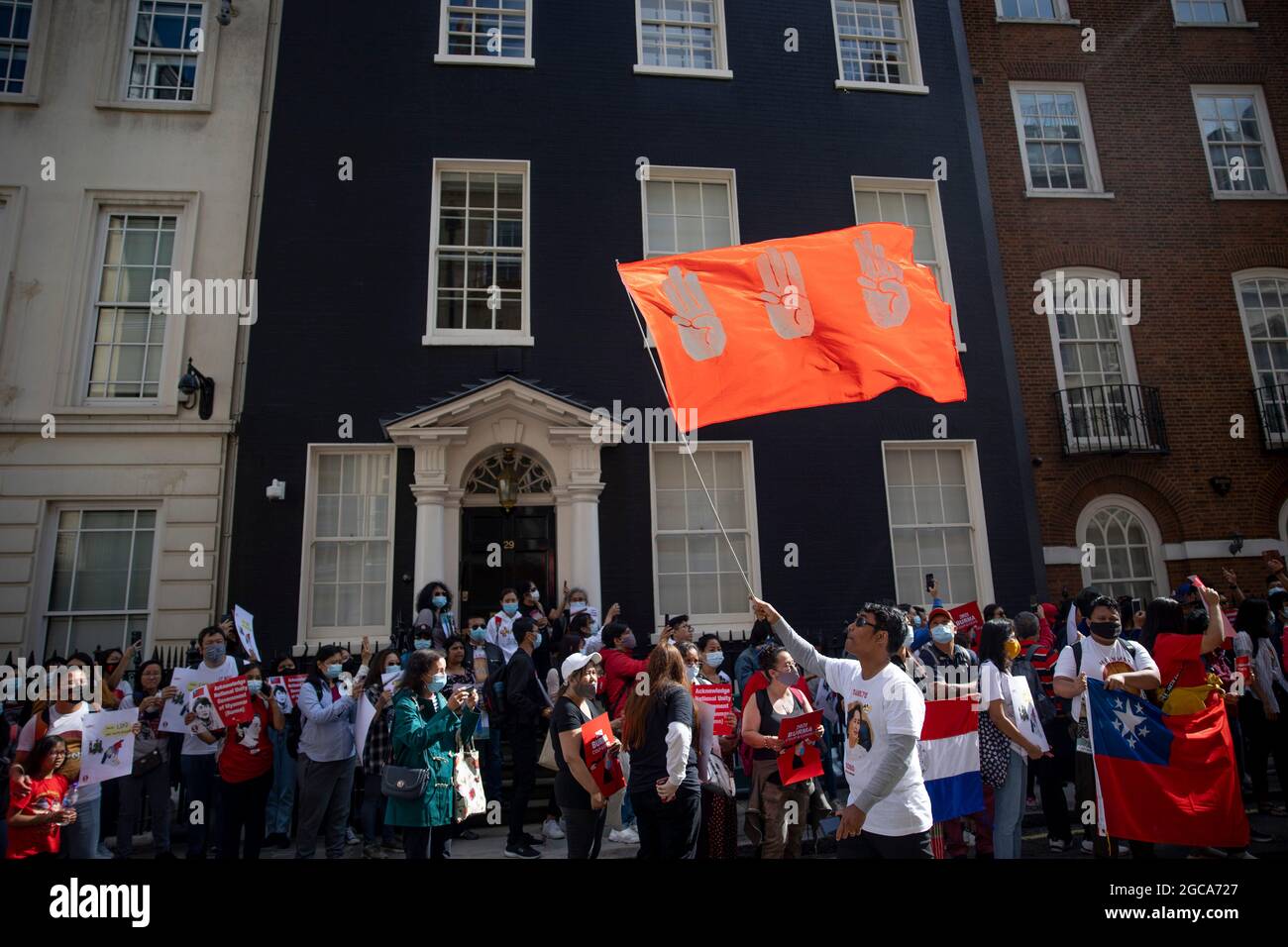 Londres, Royaume-Uni. 07e août 2021. Lors de la manifestation, un manifestant a vu un drapeau branle par un geste de « salut à trois doigts » devant l'ambassade du Myanmar. À la veille du 33e anniversaire du soulèvement du pouvoir populaire de 8888 au Myanmar, des centaines de Birmans à Londres ont défilé de la place du Parlement à l'étranger, Commonwealth & Development Office, puis à l'ambassade du Myanmar. Ils ont protesté contre la dictature génocidaire du gouvernement de coup d'État actuel au Myanmar et ont demandé une aide internationale pour reconnaître le gouvernement d'unité nationale du Myanmar. Crédit : SOPA Images Limited/Alamy Live News Banque D'Images