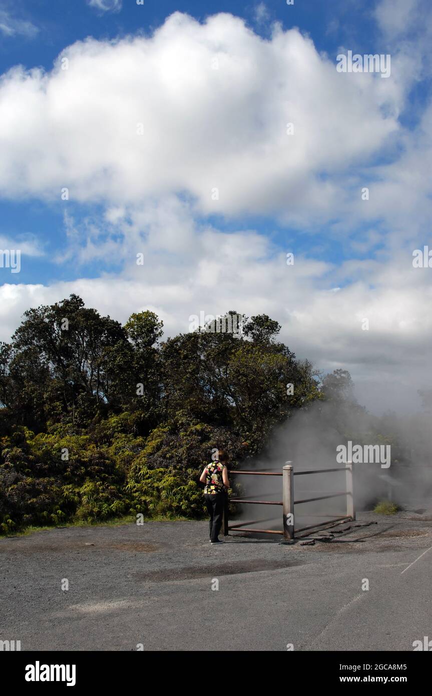 Big Island d'Hawaï les visiteurs se promène vers un évent de vapeur dans le parc national des volcans d'Hawaï. La vapeur sulfurique s'échappe d'un grand évent protégé par un barraca Banque D'Images