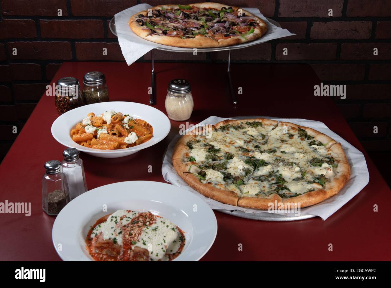 Buffet de plats à table de style familial avec la pizza végétarienne au centre. Banque D'Images