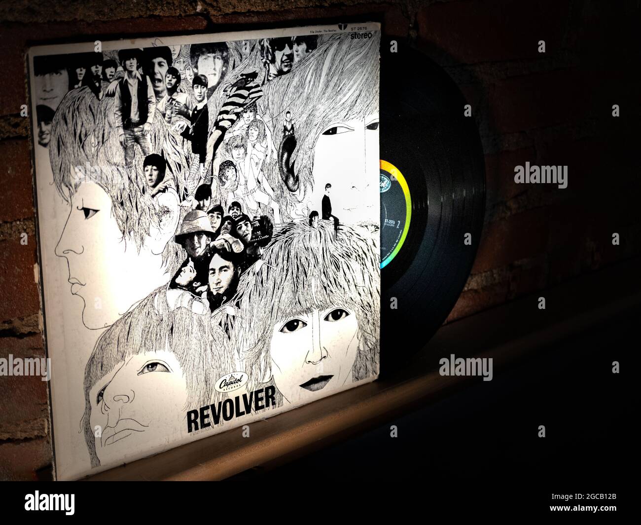 Gros plan sur le vinyle Beatles Revolver Record et la couverture penchée contre le mur de briques Banque D'Images