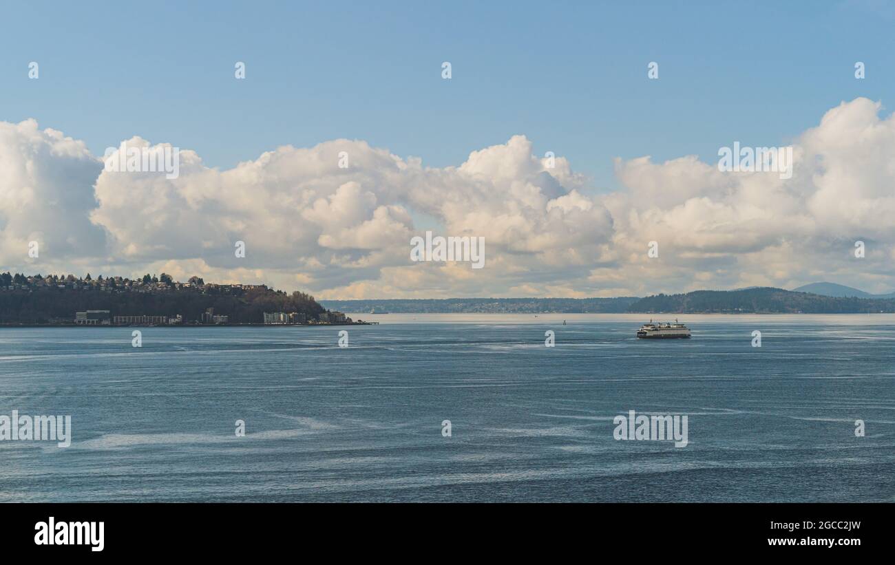 Le Washington Ferry navigue sur Elliot Bay en passant par l'ouest de Seattle et le ciel de Cloud Banque D'Images