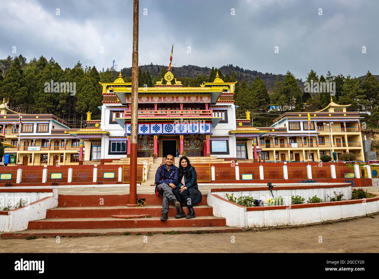 un jeune couple assis devant l'ancien monastère bouddhiste coloré à la journée image est prise au monastère de bomdila arunachal pradesh inde. Banque D'Images