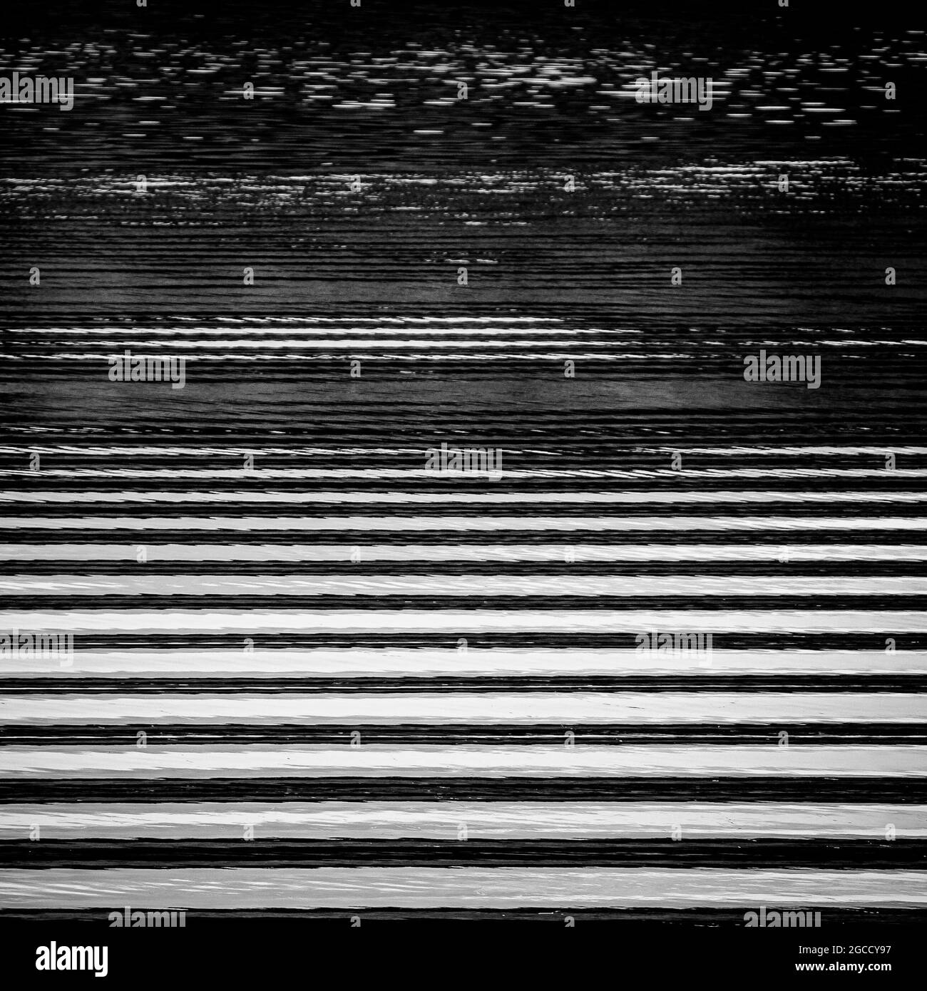 Ondulations et vagues abstraites noires et blanches à la surface de l'eau créant un motif rayé Banque D'Images