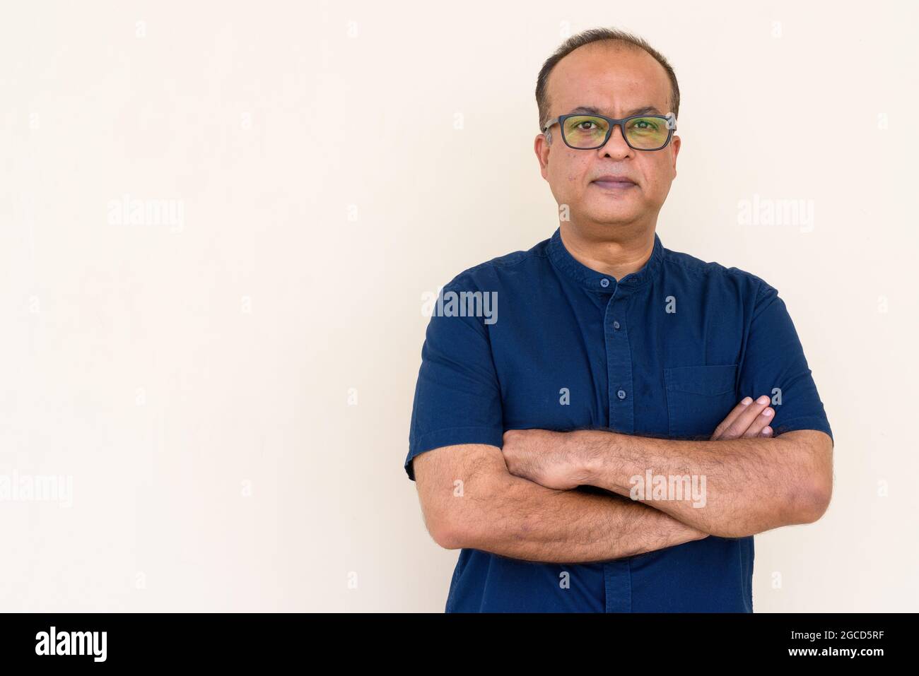 Portrait de l'Indien avec les bras croisés contre le mur plein à l'extérieur Banque D'Images