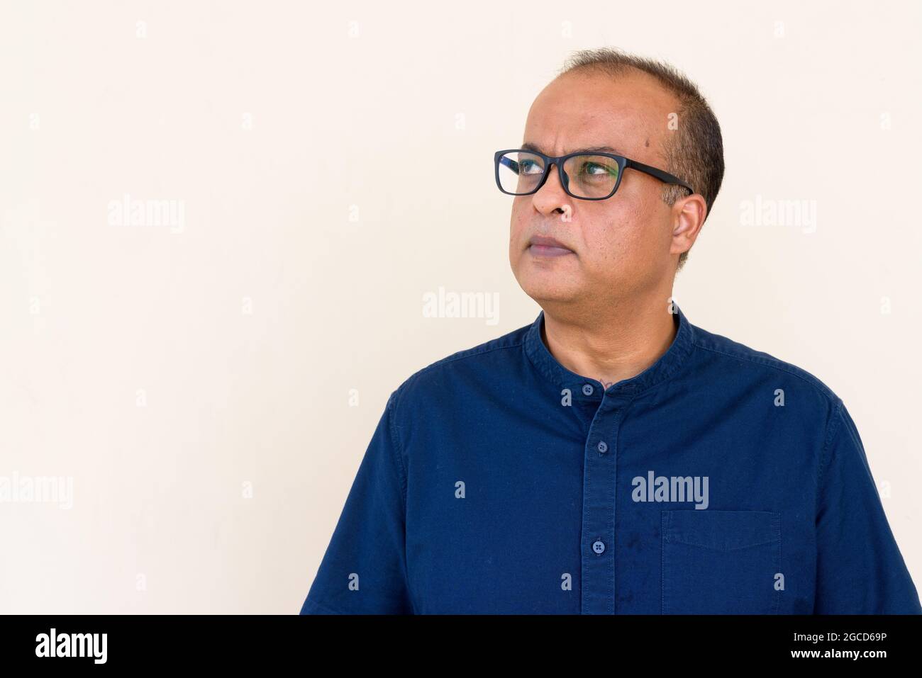 Portrait d'un Indien qui pense contre un mur plein à l'extérieur Banque D'Images