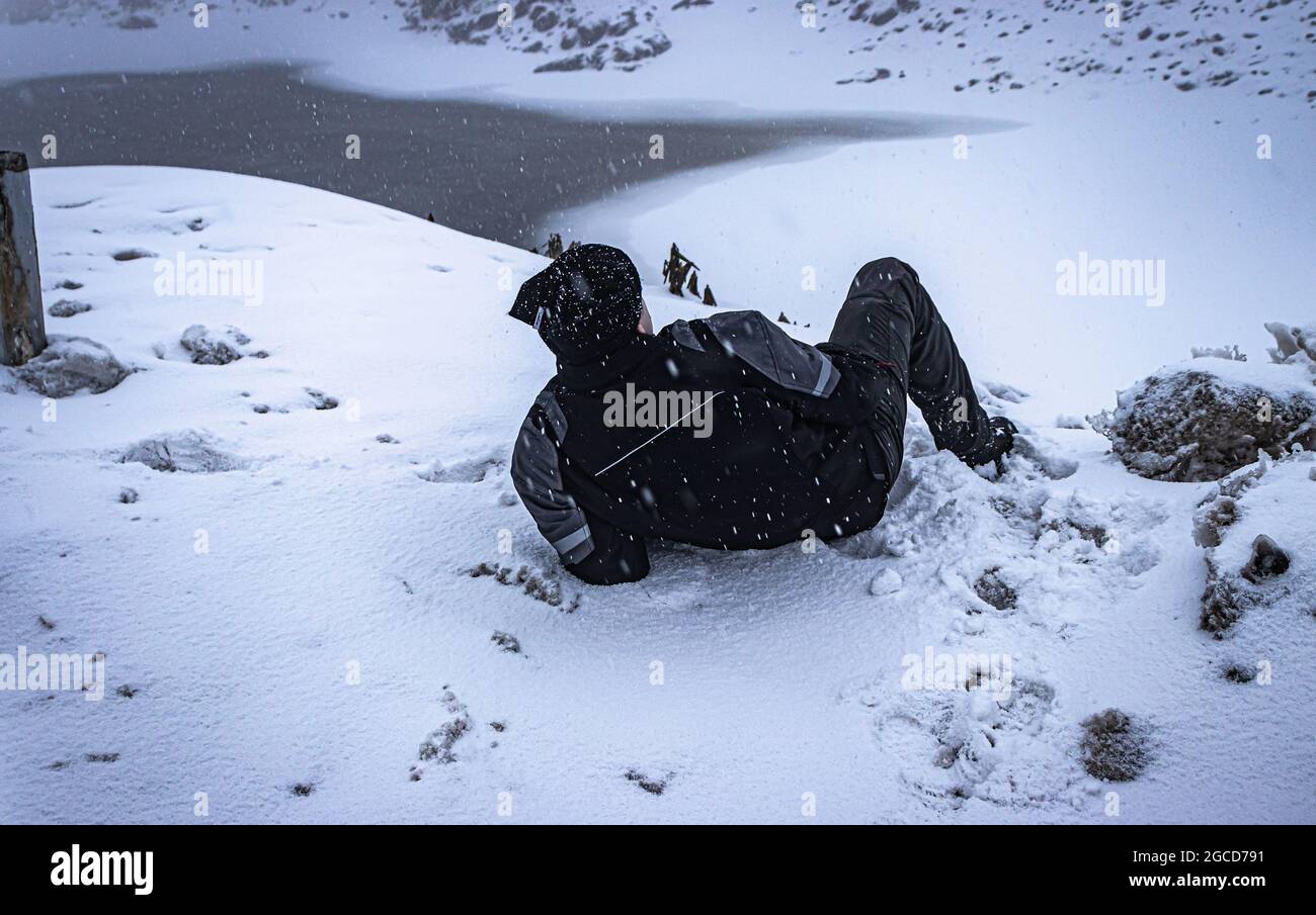 jeune homme qui profite de la chute de neige dans les montagnes de l'himalaya le matin, l'image est prise au lac madhuri tawang arunachal pradesh. Banque D'Images