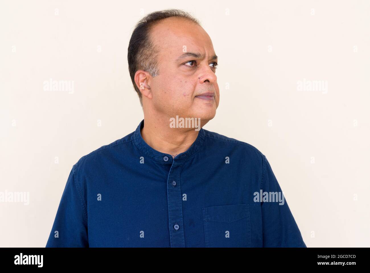 Portrait d'un Indien qui pense contre un mur plein à l'extérieur Banque D'Images