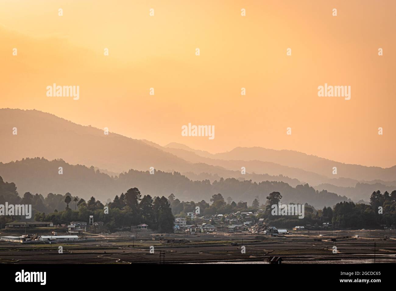 couches de montagne avec village au pied et ciel orange du matin à l'aube image est prise à ziro arunachal pradesh inde. Banque D'Images