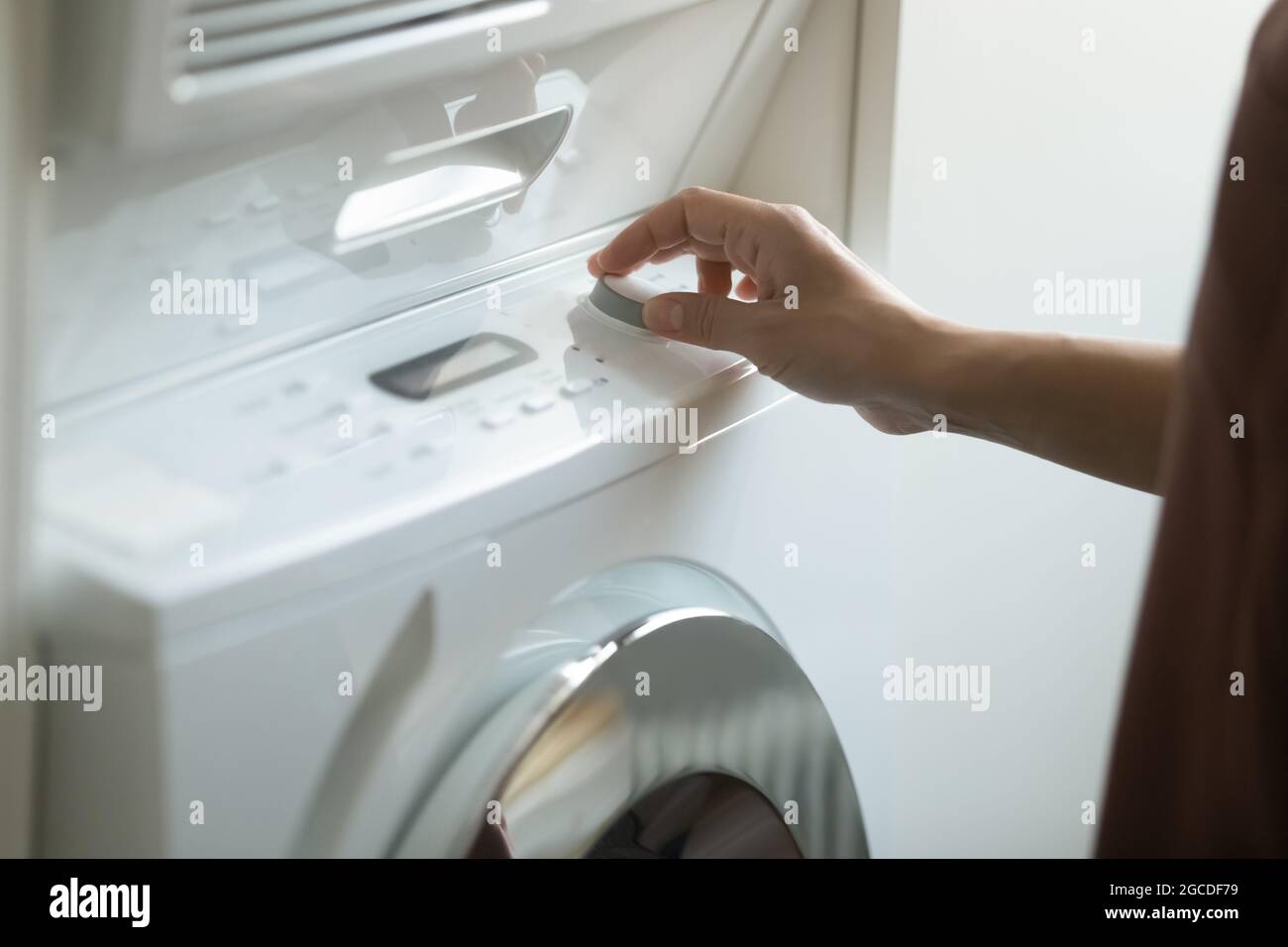 Gros plan de la femme allumez le lave-linge moderne Banque D'Images