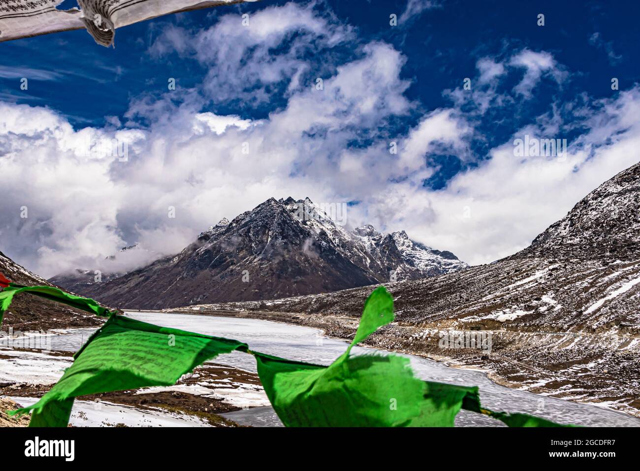montagne de calotte enneigée avec un ciel spectaculaire à travers le cadre flou des drapeaux du bouddhisme le jour l'image est prise à sela passer tawang arunachal pradesh inde. Banque D'Images