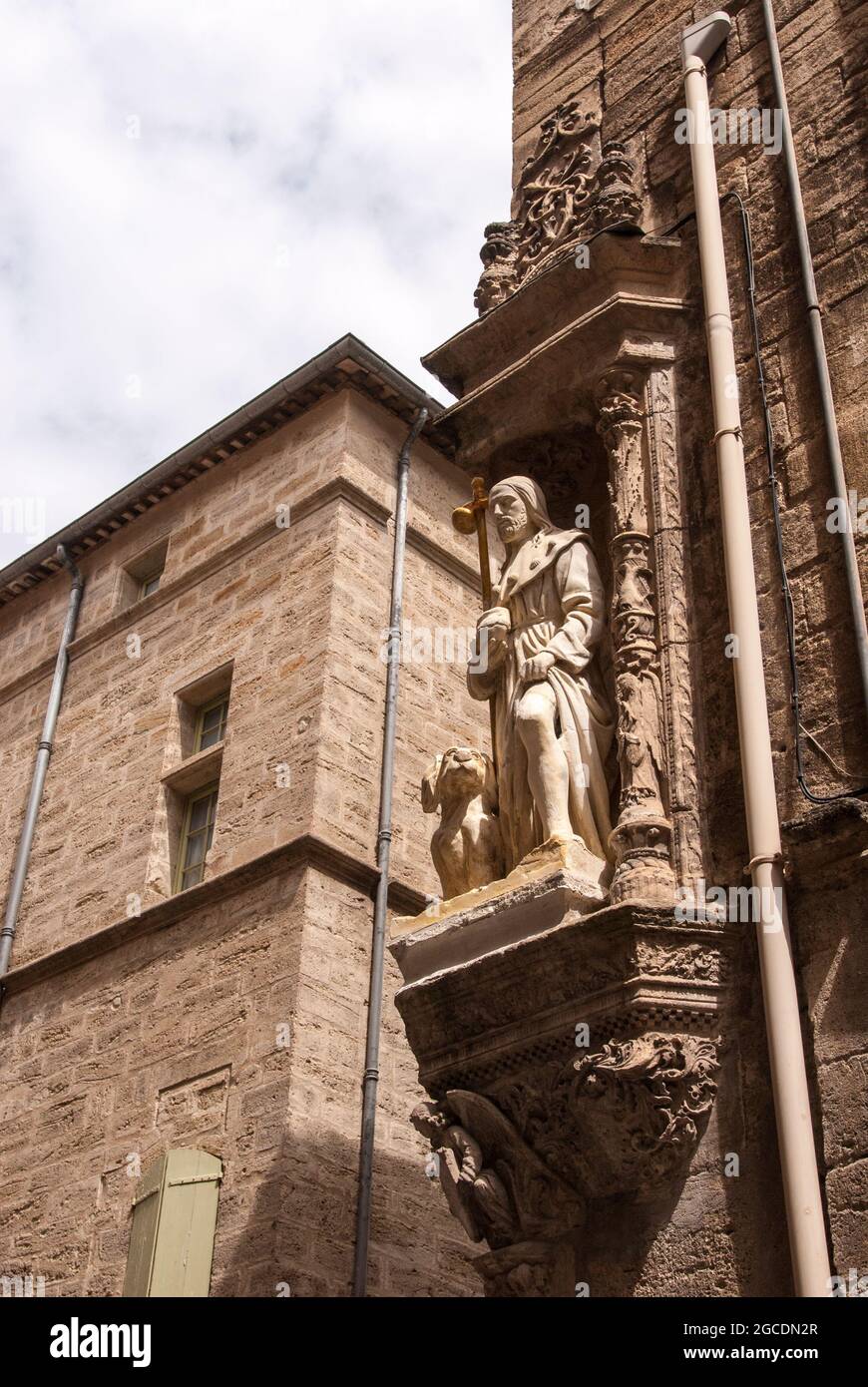Statue d'un saint haut au-dessus d'un coin de rue dans le centre historique de Pézenas. Banque D'Images
