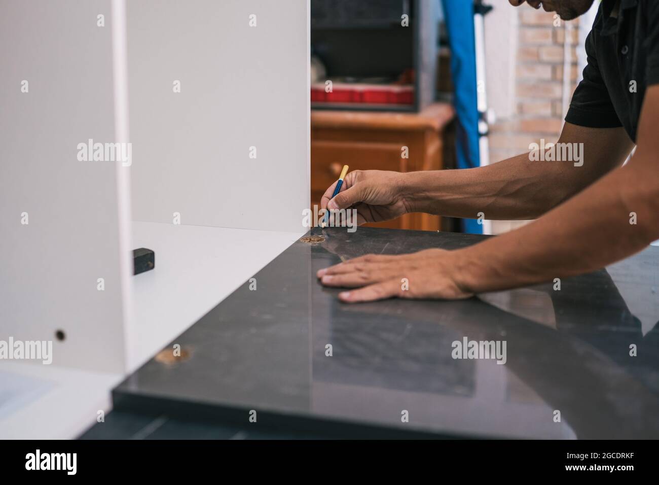 Homme traçant une ligne sur une surface dans un atelier Banque D'Images