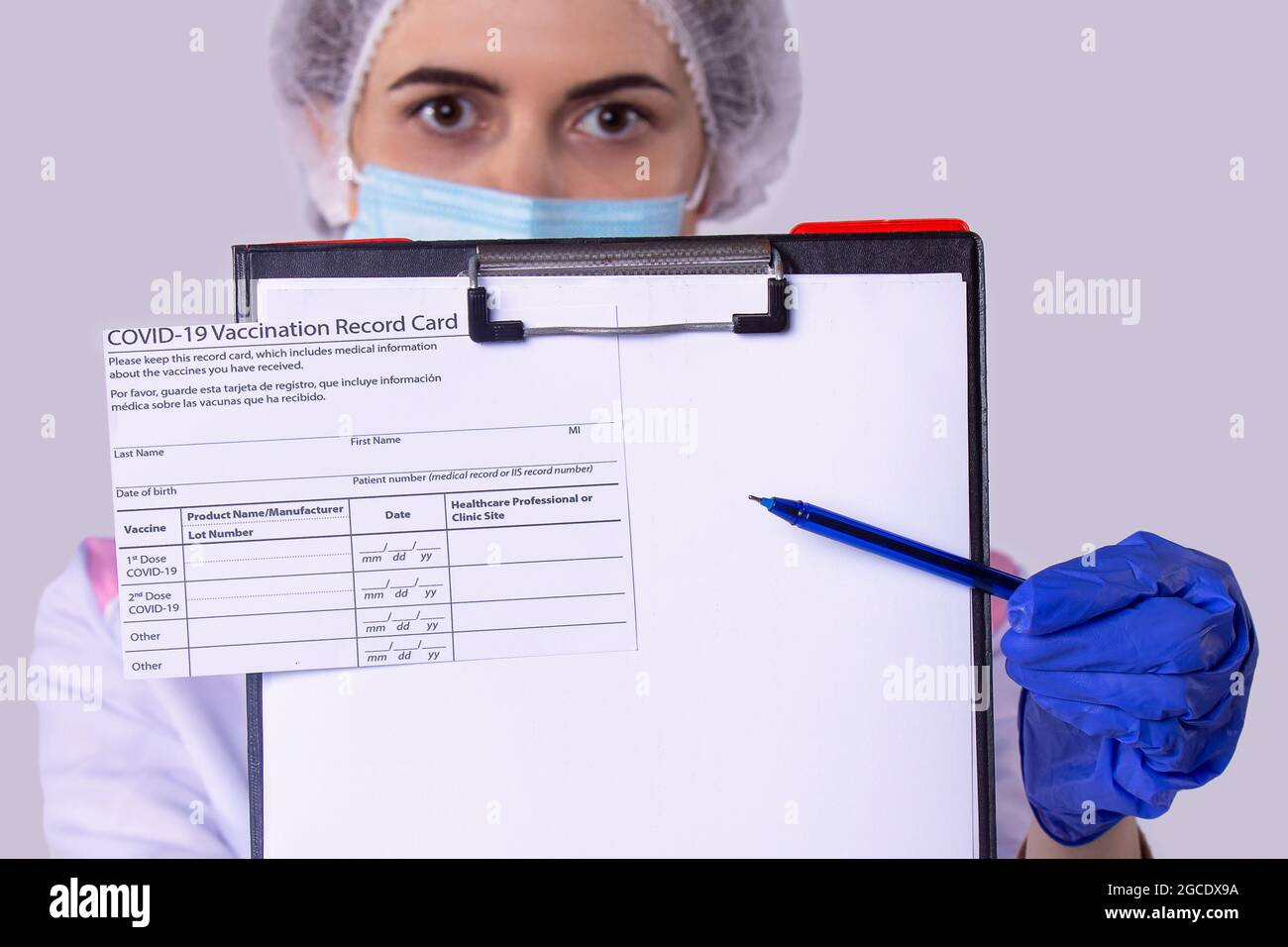 Photo en gros plan de la certification du vaccin sur le porte-document et  la femme assistante médicale en uniforme avec le masque facial portant des  gants et Photo Stock - Alamy