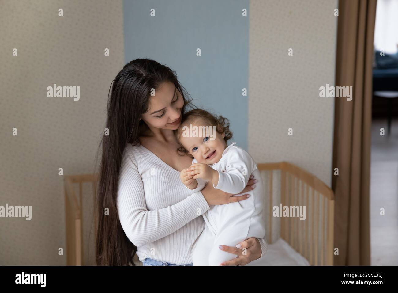 Portrait de maman aimante tenir dans les bras bébé fille Banque D'Images