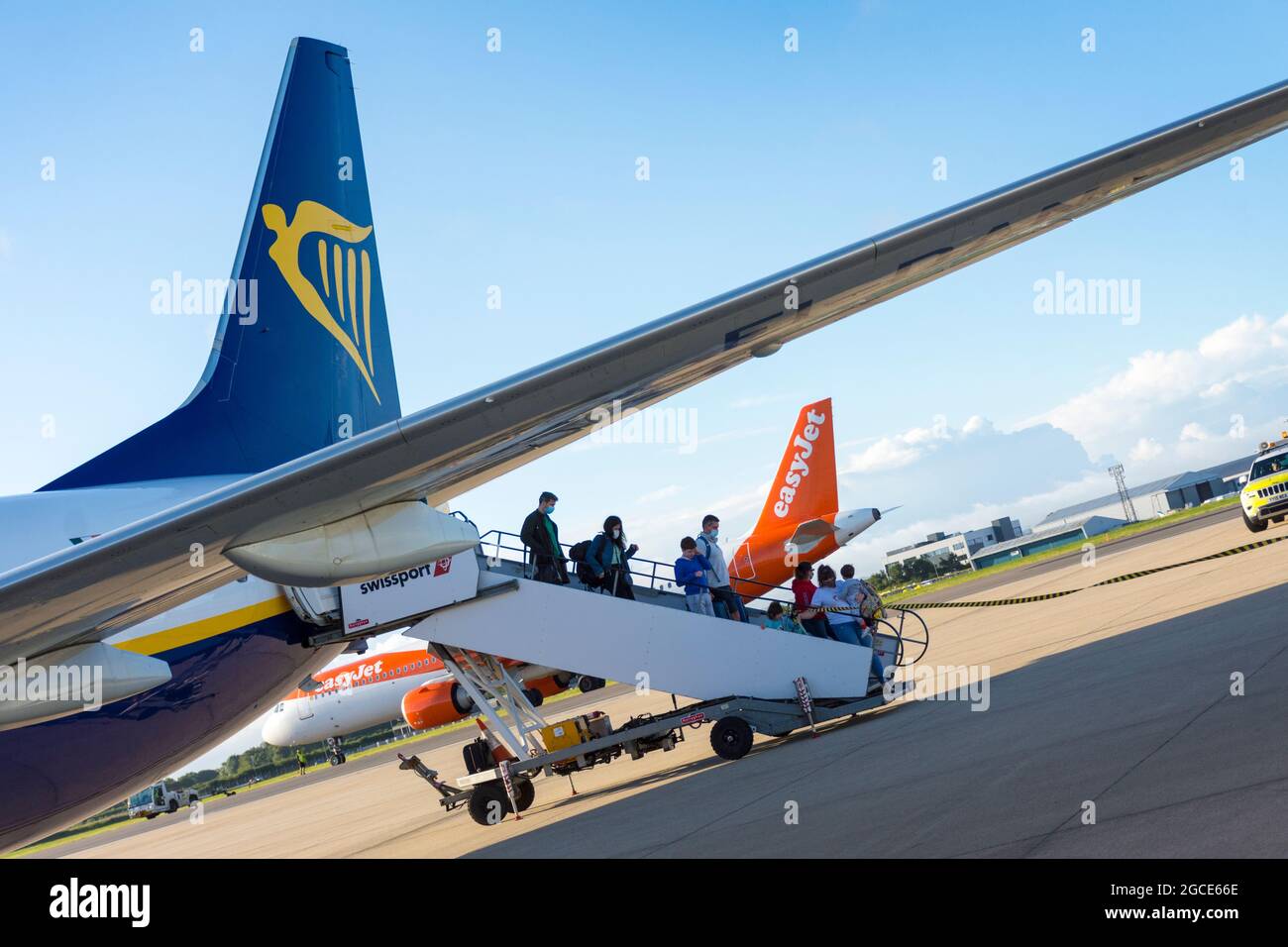 Les passagers débarquent de Ryanair tandis que les appareils Easyjet se préparent au décollage à l'aéroport de Bristol, en Angleterre, au Royaume-Uni Banque D'Images