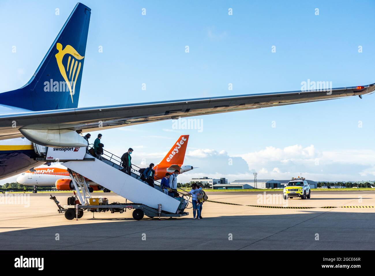 Les passagers débarquent de Ryanair tandis que les appareils Easyjet se préparent au décollage à l'aéroport de Bristol, en Angleterre, au Royaume-Uni Banque D'Images