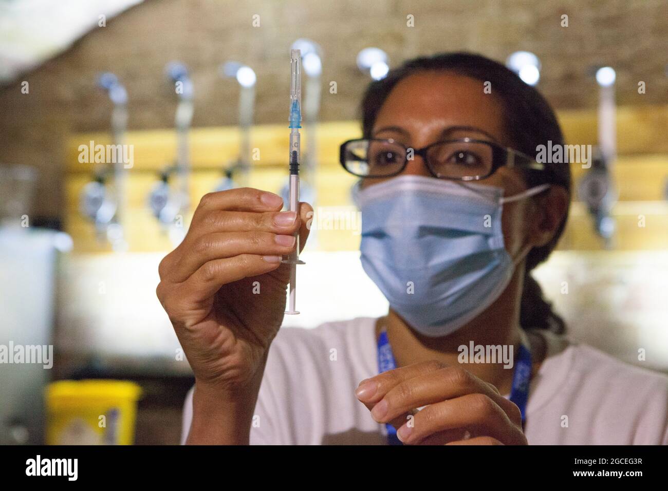 Londres, Royaume-Uni, 8 août 2021 : le personnel du NHS prépare des doses du vaccin Pfizer dans un bar bien aseptisé de la boîte de nuit Heaven, qui a ouvert ses portes le dimanche après-midi et le soir pour une clinique de vaccins pop-up. Le personnel du NHS a donné le vaccin Pfizer à des adultes qui voulaient un premier ou un deuxième jab pour tenter d'améliorer le taux de vaccination du quartier de Westminster, qui est l'un des plus bas du pays. Anna Watson/Alay Live News Banque D'Images