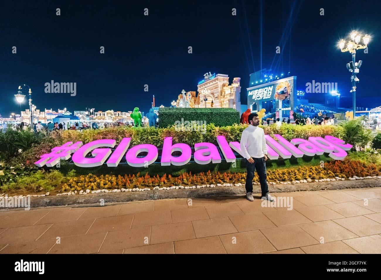 26 février 2021, Émirats Arabes Unis, Dubaï : un visiteur touristique prend une photo sur le fond de l'inscription brillante Global Village Banque D'Images
