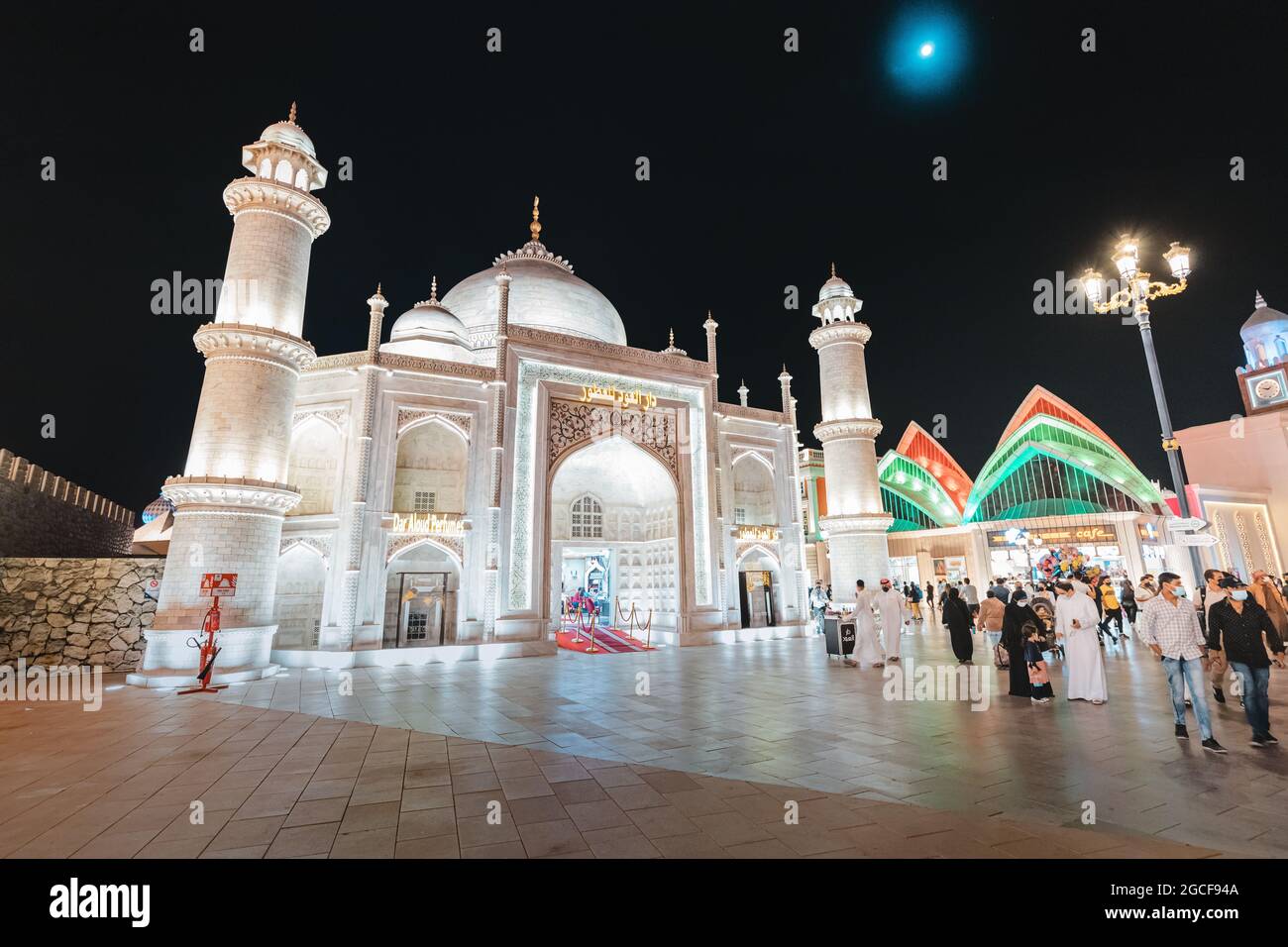 26 février 2021, Émirats Arabes Unis, Dubaï : mosquée illuminée près de l'entrée principale du Village mondial avec une foule de touristes et de visiteurs Banque D'Images