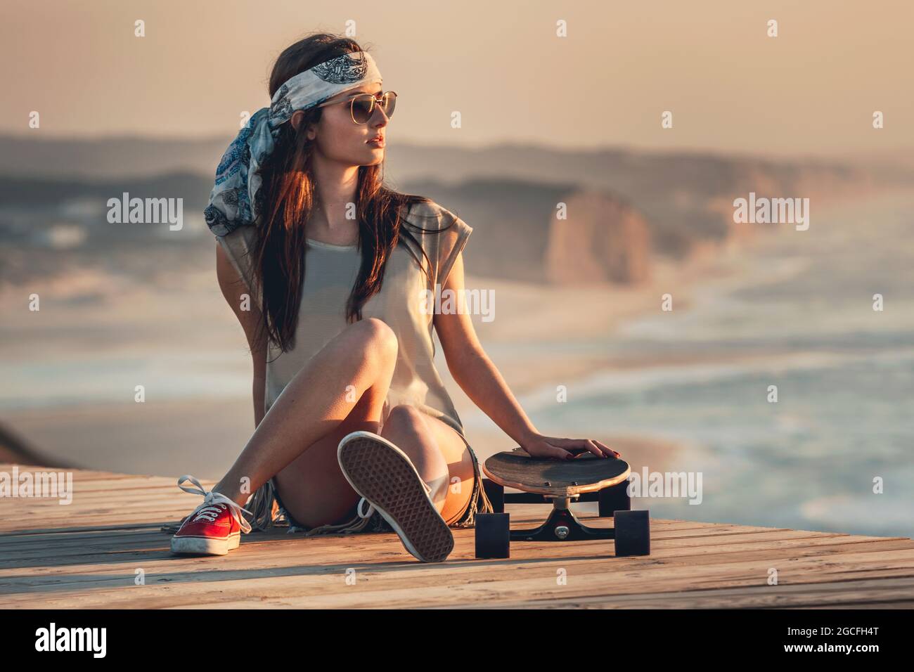 Belle fashion girl posing patineur avec un skate-board Banque D'Images