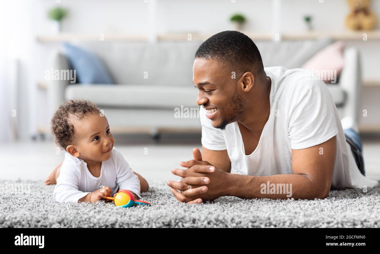 Connexion Bebe Pere Joyeux Black Man Qui S Entete Avec Un Bebe Mignon A La Maison Souriant Papa Afro Americain Et Son Adorable Petit Kid Se Detendant Sur F Photo Stock Alamy