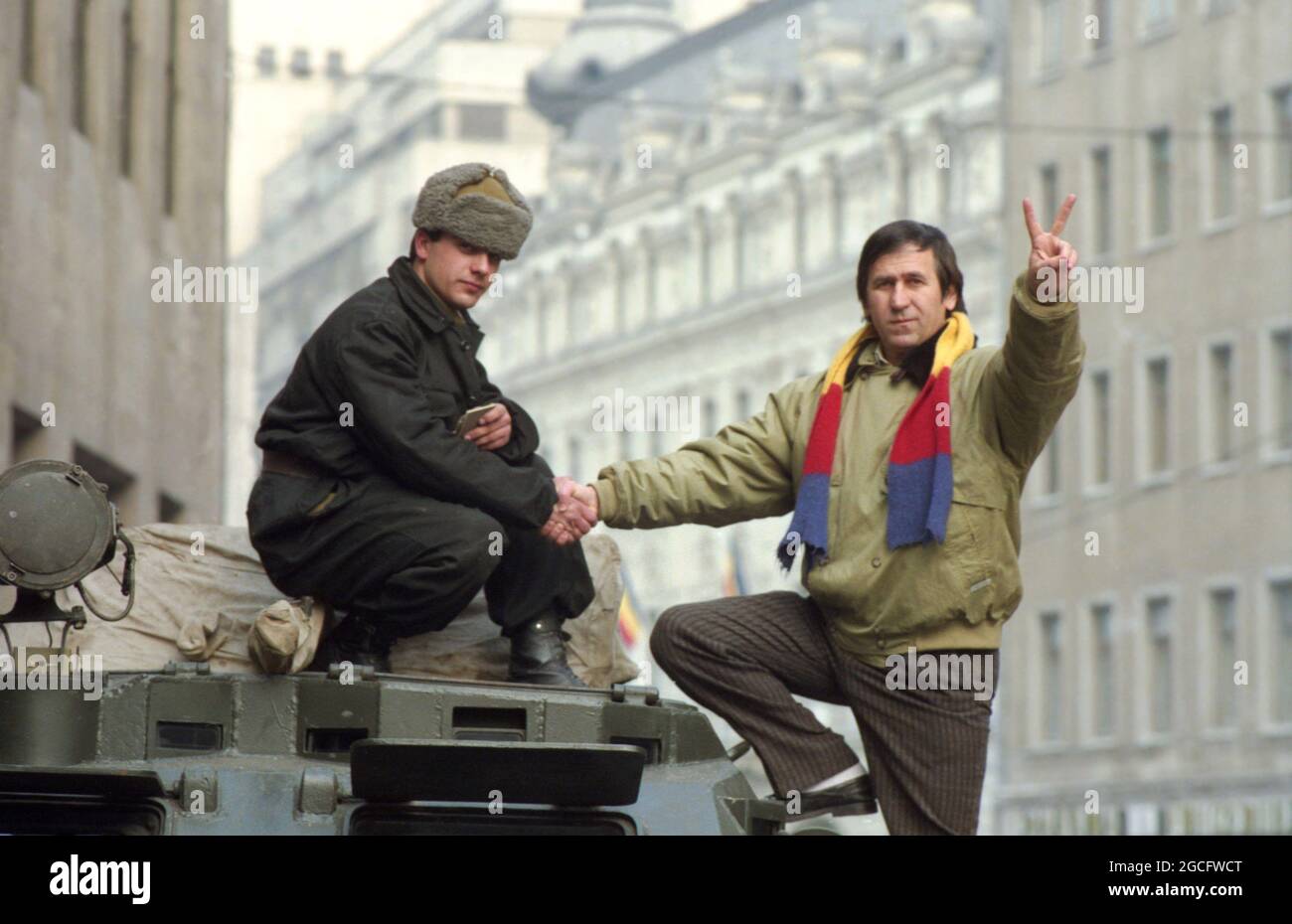Bucarest, Roumanie, janvier 1990. L'acteur George Mihaita discutant avec les soldats dans les rues dans les jours troumpants juste après la chute du communisme. Banque D'Images