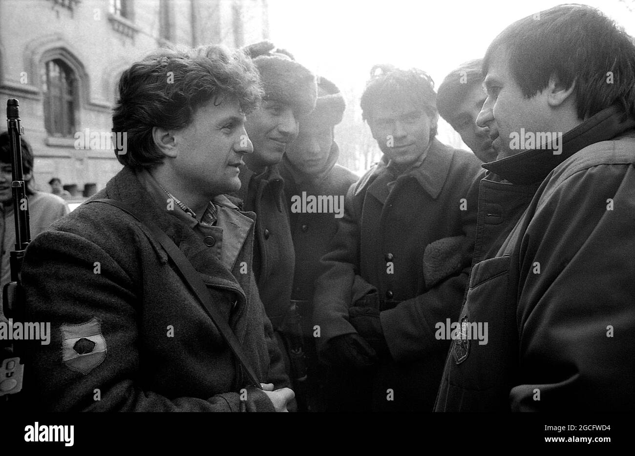 Bucarest, Roumanie, janvier 1990. L'acteur George Mihaita discutant avec les soldats dans les rues dans les jours troumpants juste après la chute du communisme. Banque D'Images