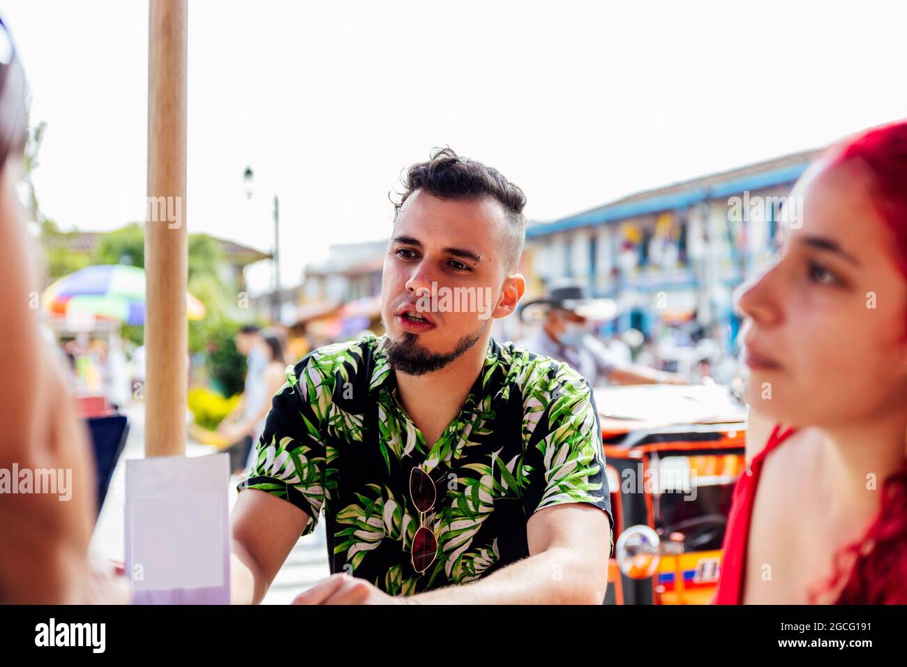 Objectif sélectif d'un jeune Latino assis à une table dans un parc d'une ville colombienne Banque D'Images