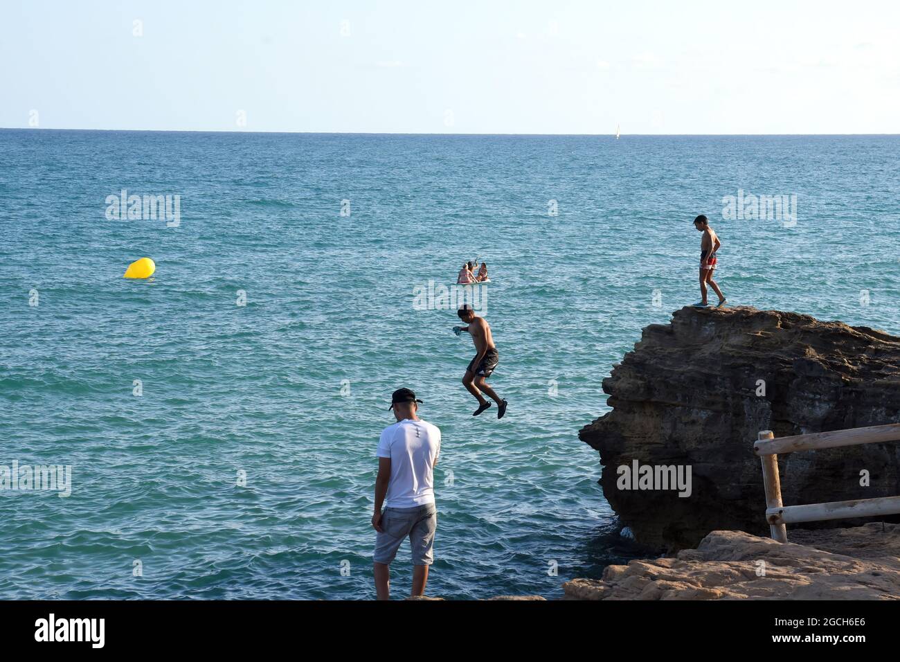 Roda de Bara, Espagne. 05 août 2021. Un jeune homme plonge dans la mer depuis une falaise à la plage du Roc de Sant Gaieta à Roda de Bara.les jeunes sautent des falaises à la plage du Roc de Sant Gaieta à Roda de Bara (Tarragone Espagne), une pratique qui est interdite, dangereux et peut causer de graves blessures corporelles et même la mort par l'impact contre les roches. Crédit : SOPA Images Limited/Alamy Live News Banque D'Images