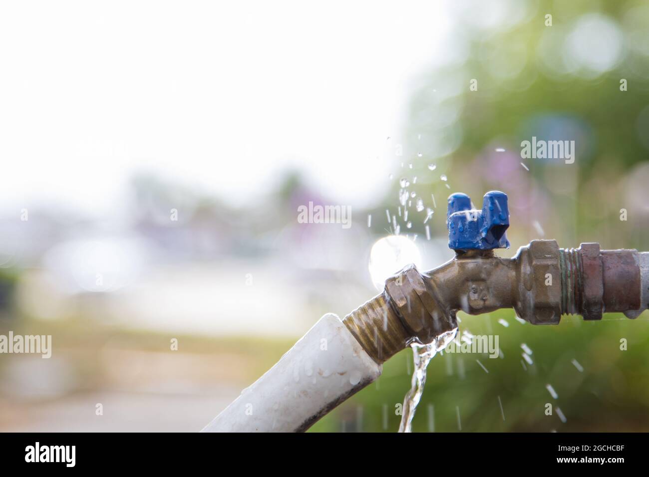 Robinet d'eau extérieur avec tuyau d'arrosage qui fuit Photo Stock - Alamy