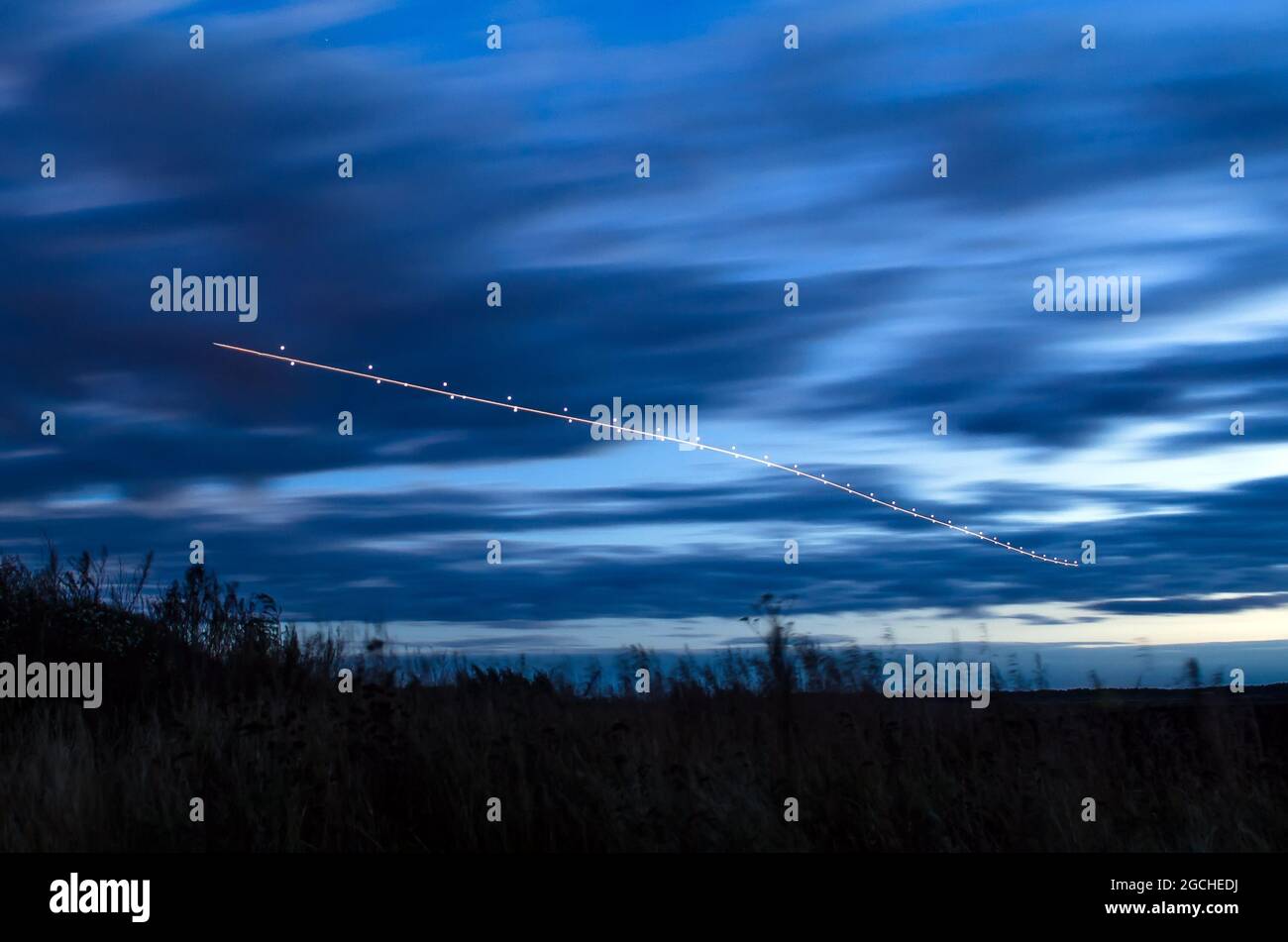 Lumières de nuit, pistes de lumière dans le mouvement de l'avion en exposition longue Banque D'Images