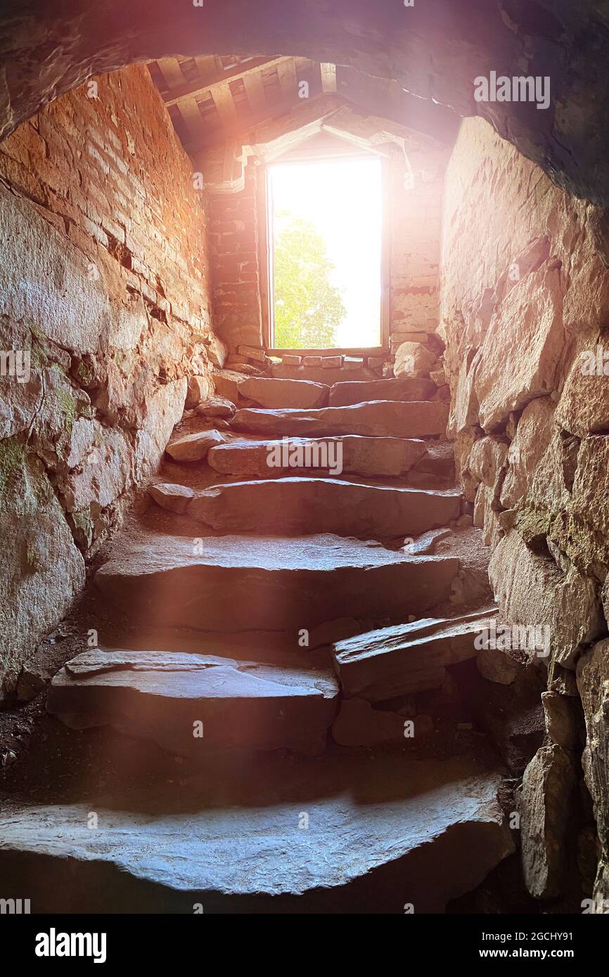 Escaliers en pierre escarpés de donjon de cave sombre, lumière du soleil entrant, espoir et liberté concept Banque D'Images