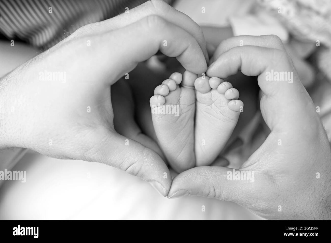 Les pieds du nouveau-né dans les mains de la maman gros plan. Banque D'Images