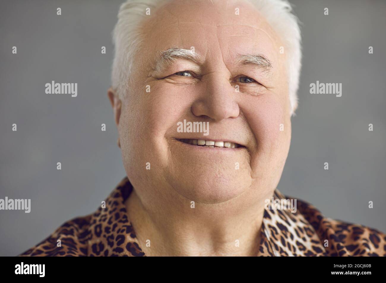 Gros plan portrait en studio d'un homme de haut niveau gai souriant et regardant l'appareil photo Banque D'Images