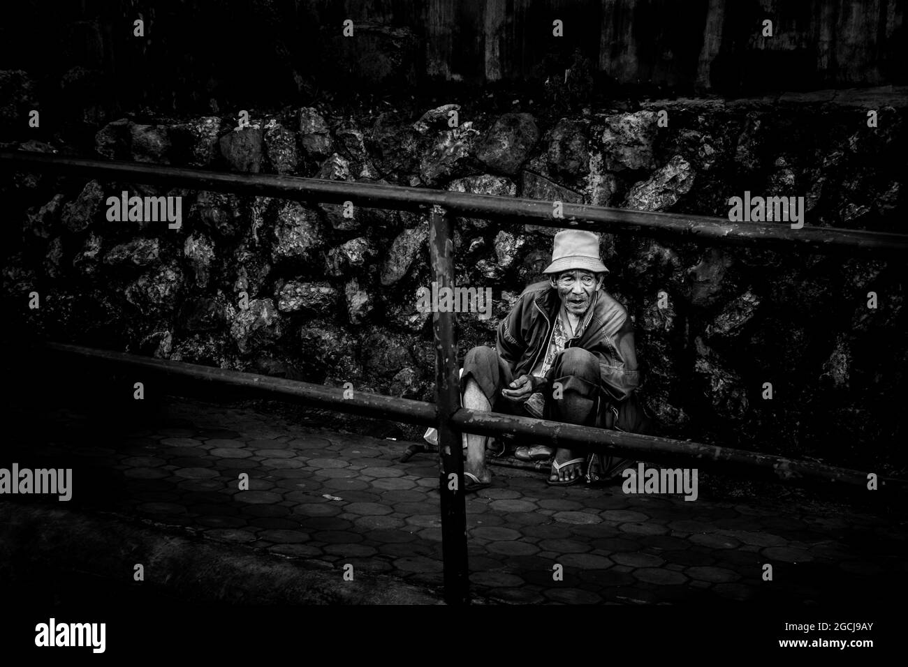 BAGUIO, PHILIPPINES - 18 décembre 2016 : photo en niveaux de gris d'un vieil homme qui supplie pour des almes à Baguio City, Philippines Banque D'Images