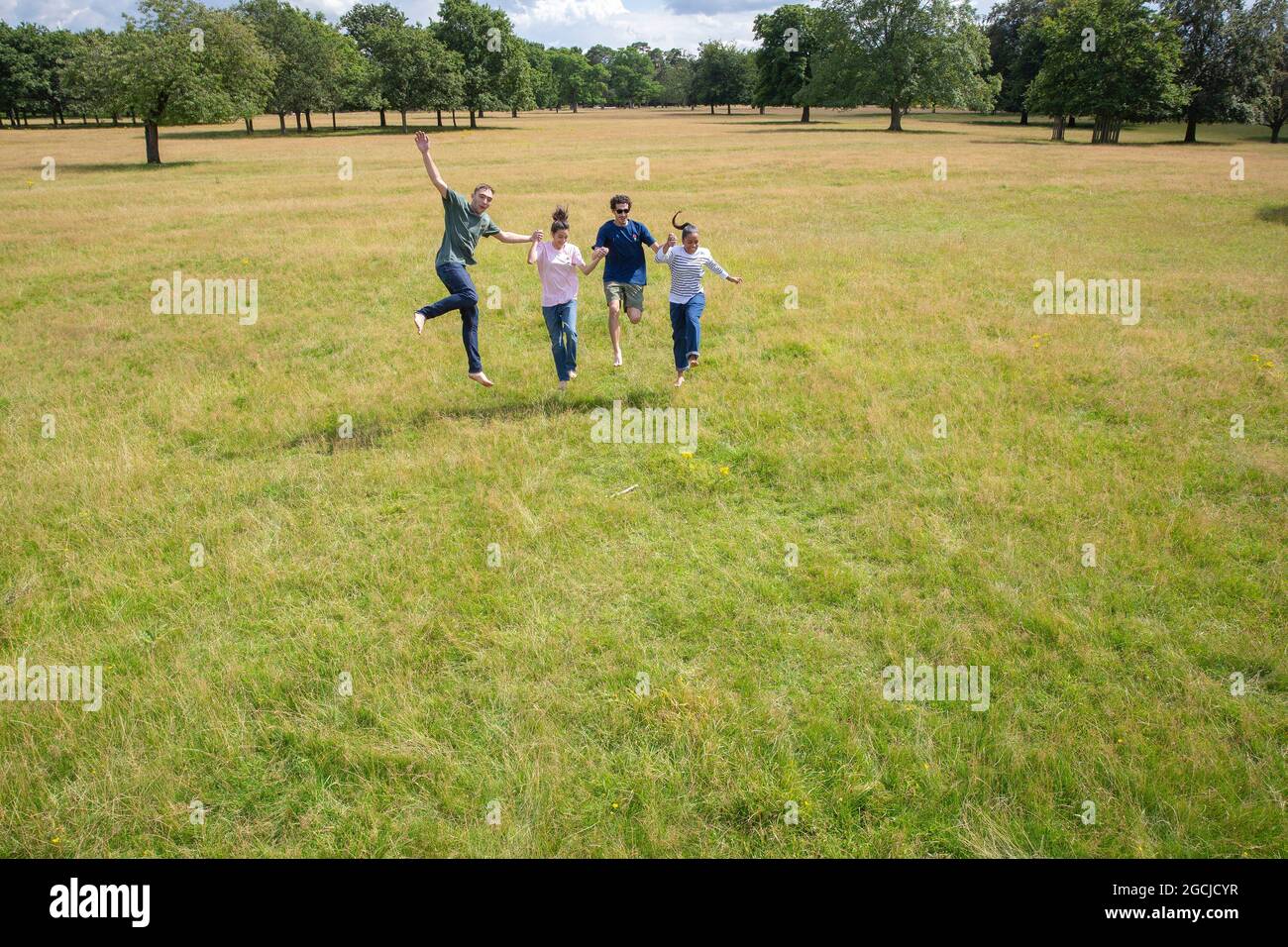 Un groupe de jeunes court et sautant dans le parc. Banque D'Images