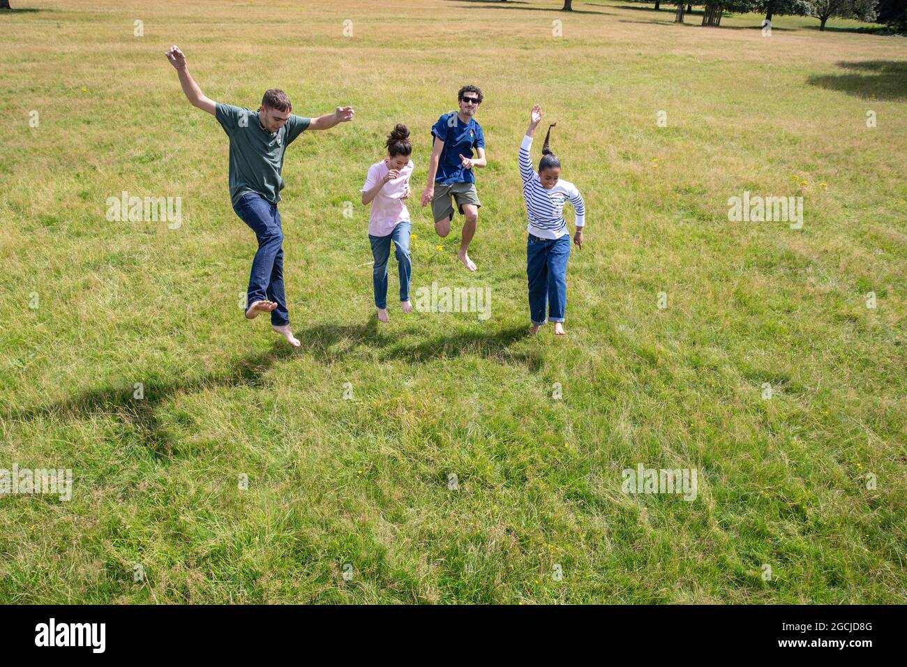 Un groupe de jeunes court et sautant dans le parc. Banque D'Images