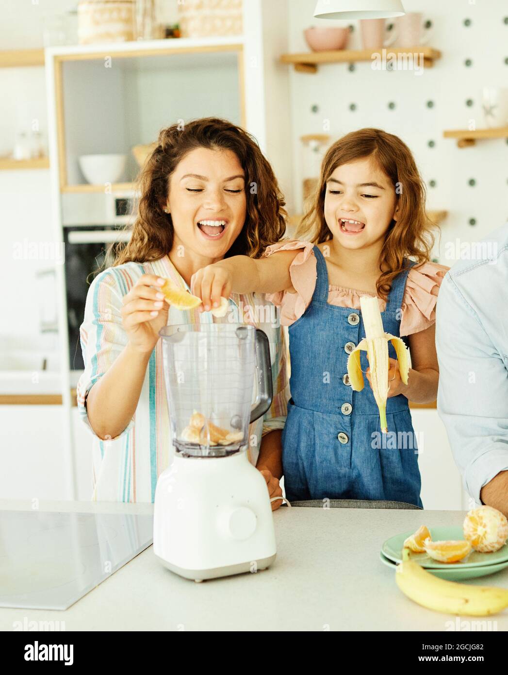 famille enfant cuisine nourriture fille mère fruits smoothie jus petit déjeuner heureux ensemble Banque D'Images