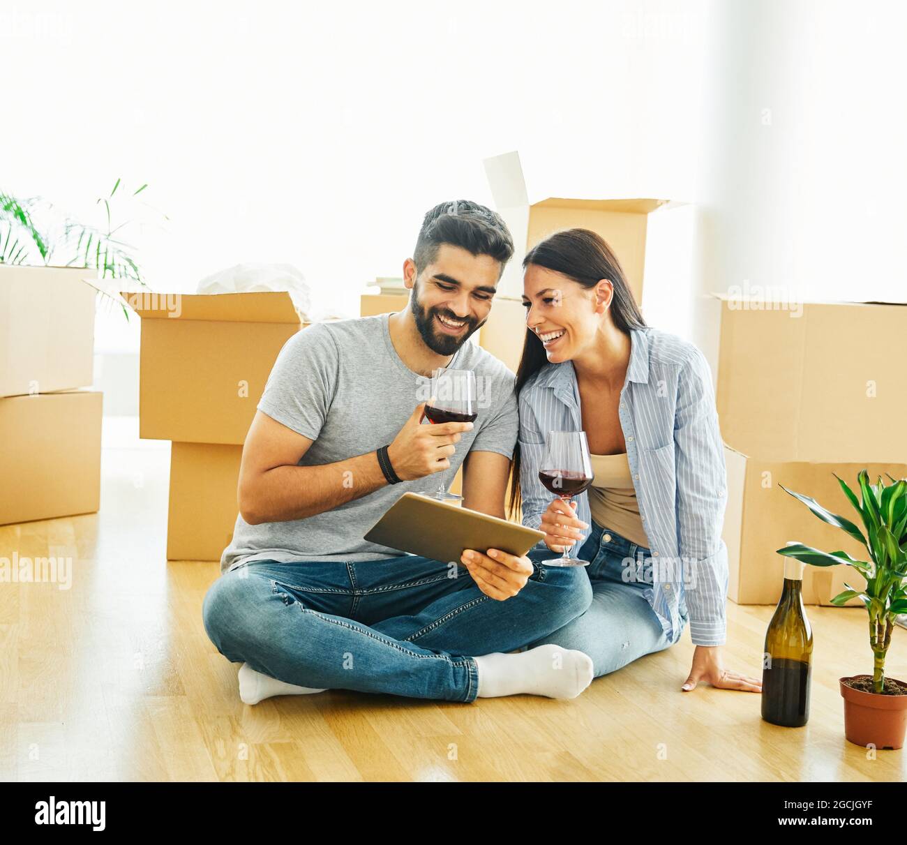 femme couple homme boîte maison déménagement heureux appartement ensemble romantique relocalisation vin comprimé Banque D'Images