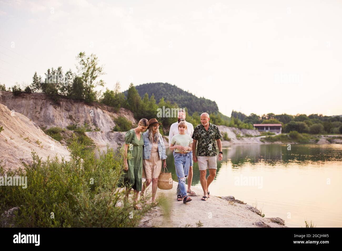 Bonne famille multigénération pendant les vacances d'été, à pied au bord du lac. Banque D'Images