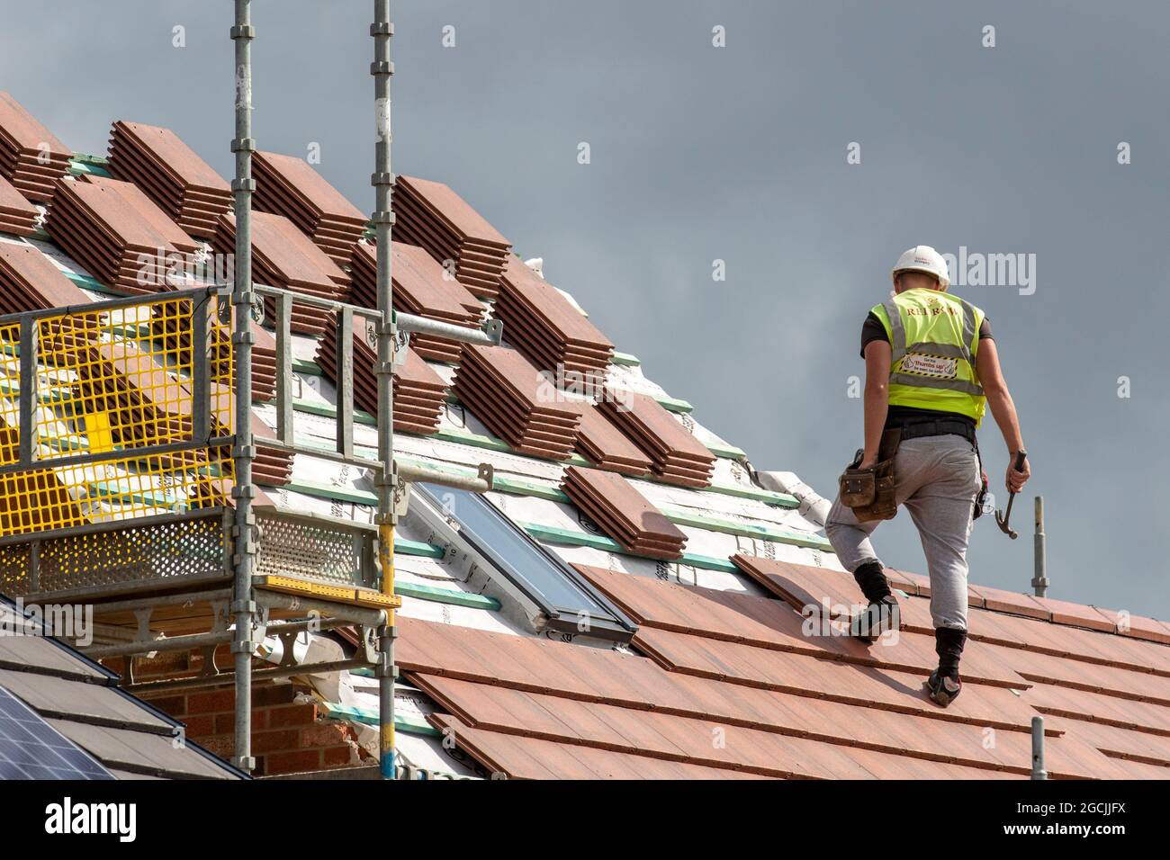 Roof Slater Tiler Keepmoat demeure un site de développement à Chorley. Constructeurs commencer la construction sur ce grand nouveau logement, les toits en bois lattes dormer, faîte, chevrons et dortoirs, les membres de toit, les panneaux de enseigne de joue bois d'embarquement soffit charpente et le revêtement apex poutres de toit. Dormeur de toit incliné construit sur terrain vert, Royaume-Uni Banque D'Images