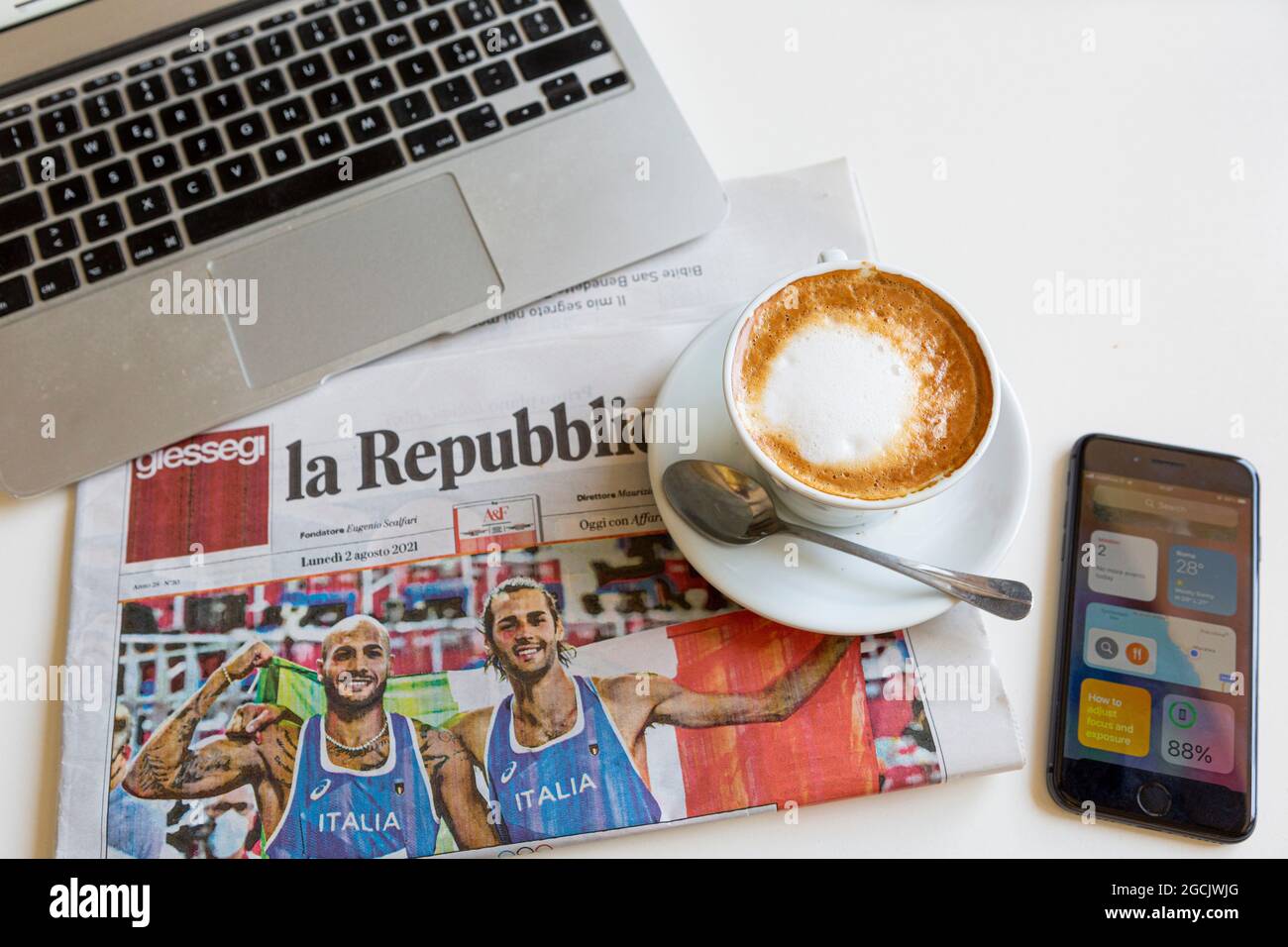 Titre du journal du matin à la Repubblica deux médailles d'or athlétiques pour l'Italie avec cappuccino et ordinateur et téléphone Banque D'Images