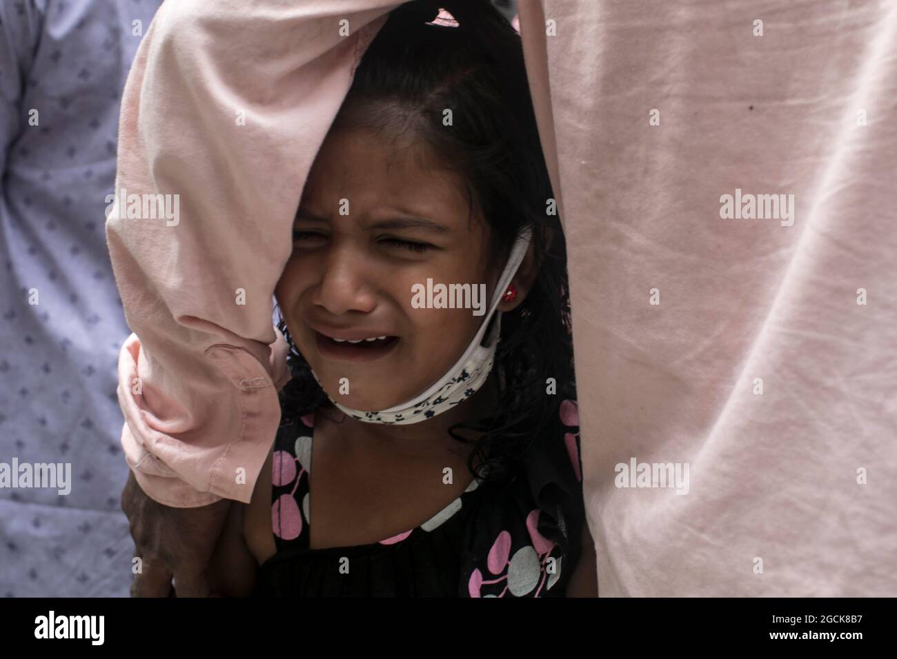 Non exclusif: DHAKA, BANGLADESH - AOÛT 7: Un enfant désarpe, alors que voir comme sont livrés les restes dans les cercueils, des parents qui sont morts dans la dea Banque D'Images